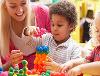 Image of an adult and two children playing with blocks